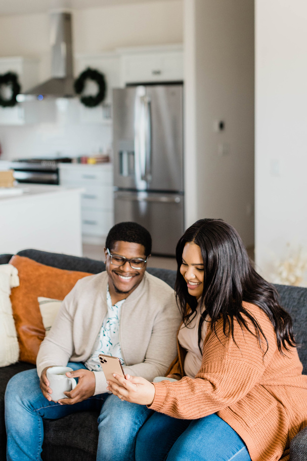 Happy Couple Sitting on Sofa Video Calling Family